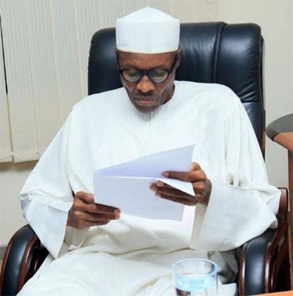 Buhari seated reading document 4