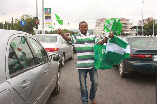 A young man selling Nigerian flag on the street of Abuja on Independence Day