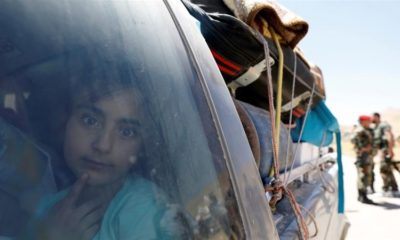 A Syrian refugee girl who left Lebanon looks through a window as she arrives in Qalamoun Syria