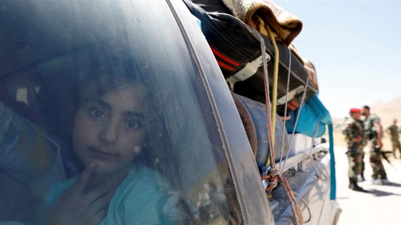 A Syrian refugee girl who left Lebanon looks through a window as she arrives in Qalamoun Syria