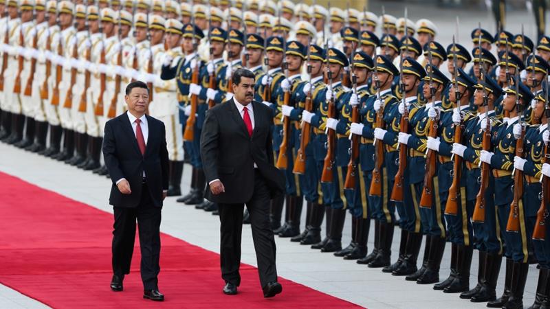 Chinese President Xi Jinping walks next to Venezuelas President Nicolas Maduro during his welcoming ceremony in Beijing