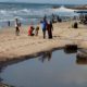 Palestinians walk past a pool of sewage on a beach in the northern Gaza Strip