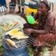 cropped a woman sells fresh grilled corn at a roadside market in nigerias BE1K69