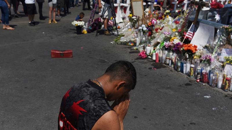 A man prays at a memorial three days after a mass shooting at a Walmart store in El Paso Texas US
