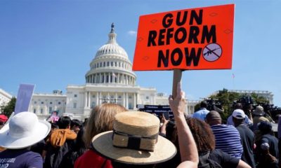 A protester holds up a sign during a demonstration calling for Congress to pass gun safety laws at the US Capitol in Washington