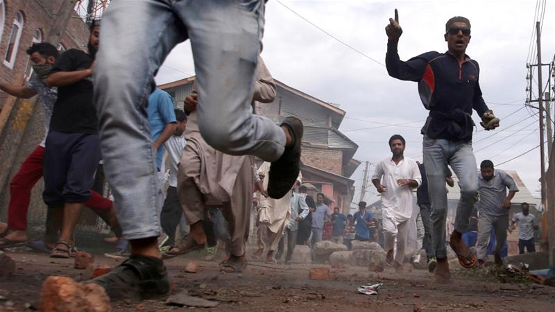 Kashmiris run for cover as Indian security forces unseen fire tear gas shells during clashes in Srinagar