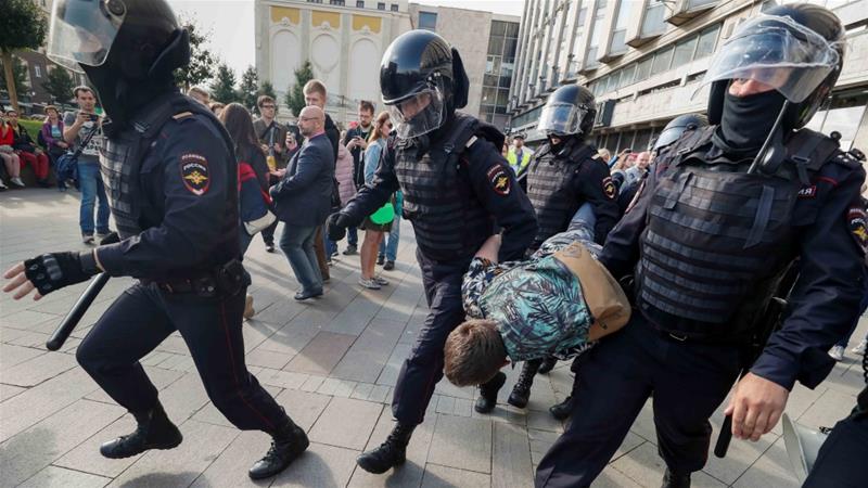 Law enforcement officers arrest a participant in a rally calling for opposition candidates to be registered for elections for the Moscow city Duma in Moscow