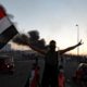 A demonstrator holds an Iraqi flag at a protest following four days of nationwide anti government protests