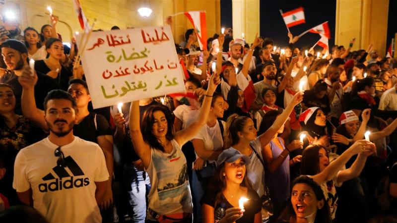 Demonstrators carry national flags and light candles during an anti government protest near al Amin mosque in Beirut Lebanon