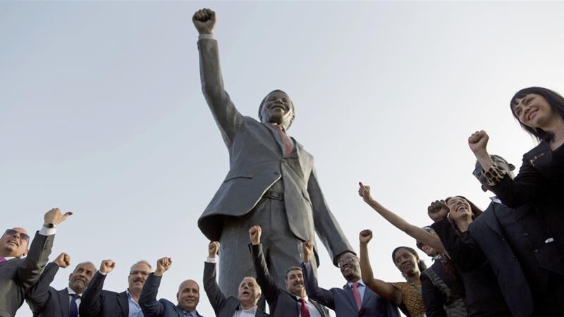 Palestinians pose for a picture with a sculpture of the first democratically elected South African President Nelson Mandela in the West Bank city of Ramallah, on April 26, 2016. [AP/Nasser Nasser]