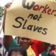 A migrant domestic worker holds up a placard during a parade in Beirut to support the rights of migrant domestic workers in Lebanon