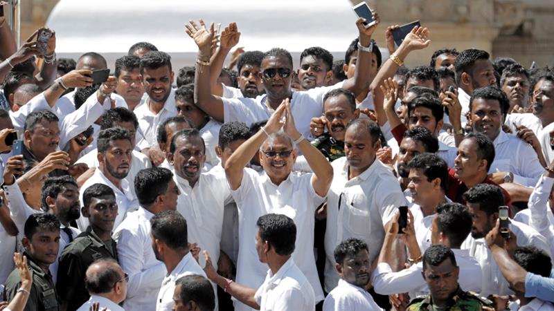 Sri Lankas President Gotabaya Rajapaksa waves at his supporters as he leaves after the presidential swearing in ceremony in Anuradhapura Sri Lanka