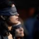 A protestor wearing a blindfold takes part in a protest in solidarity with rape victims and to oppose violence against women in India