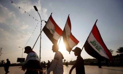 Demonstrators carry Iraqi flags during continuing anti government protests in Basra Iraq