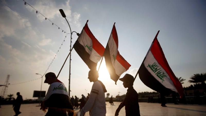 Demonstrators carry Iraqi flags during continuing anti government protests in Basra Iraq