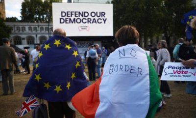 A woman wearing an Irish flag and a man wearing an EU flag demonstrate in front of the parliament at Westminster in London on September 4 2019