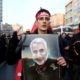 An Iranian man holds a picture of General Qassem Soleimani during his funeral procession in Tehran on January 6 2020