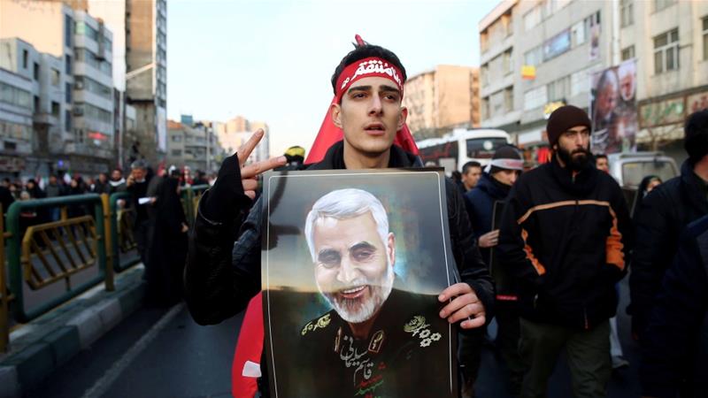 An Iranian man holds a picture of General Qassem Soleimani during his funeral procession in Tehran on January 6 2020