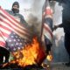 Demonstrators burn American and British flags during a protest against the assassination of the Iranian Major General Qassem Soleimani in Tehran on January 3 2020