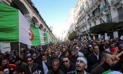 Demonstrators carry a national flag during an anti government rally in Algiers on January 3 2020
