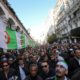 Demonstrators carry a national flag during an anti government rally in Algiers on January 3 2020