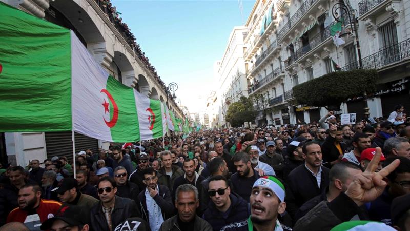 Demonstrators carry a national flag during an anti government rally in Algiers on January 3 2020
