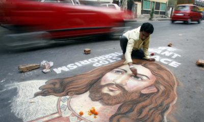 Indian painter Swapan Das gives finishing touches to a portrait of Jesus Christ on a busy road in the eastern Indian city of Kolkata on December 24 2008