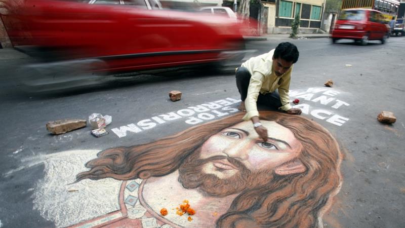 Indian painter Swapan Das gives finishing touches to a portrait of Jesus Christ on a busy road in the eastern Indian city of Kolkata on December 24 2008