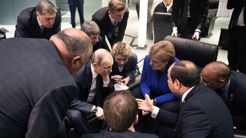 Russian President Vladimir Putin German Chancellor Angela Merkel and other officials talk during a conference on Libya at the German Chancellery in Berlin on January 19 2020