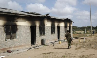 A member of Kenyas security forces walks past a damaged police post after an attack by al Shabab in the settlement of Kamuthe in Garissa county Kenya on January 13 2020
