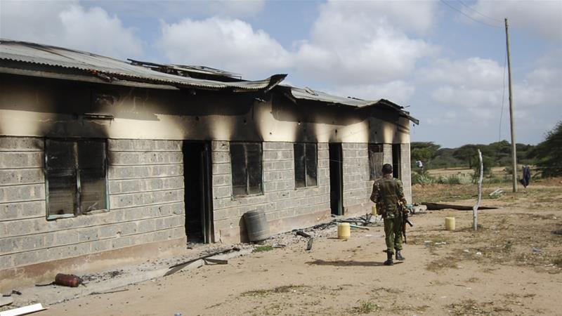 A member of Kenyas security forces walks past a damaged police post after an attack by al Shabab in the settlement of Kamuthe in Garissa county Kenya on January 13 2020