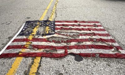 A partially burned American flag lies on the street near the spot where Michael Brown was killed in Ferguson Missouri August 9 2015