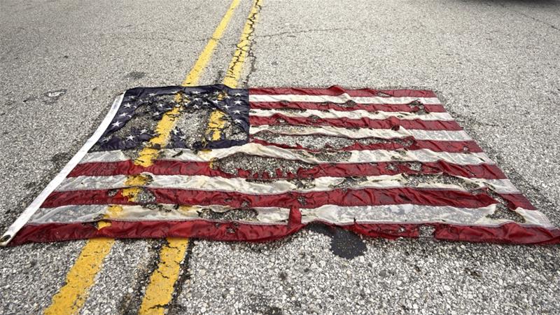 A partially burned American flag lies on the street near the spot where Michael Brown was killed in Ferguson Missouri August 9 2015
