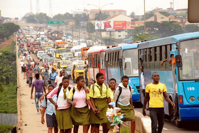 Pupils and other stranded commuters trekking at Ojota Long Bridge on Ikorodu Road Lagos