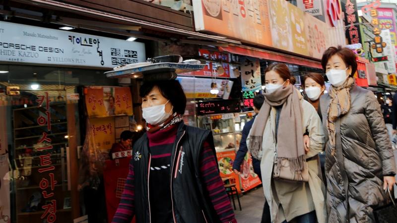 Women wearing masks as a preventive measure against the coronavirus walk at a traditional market in Seoul South Korea February 20 2020