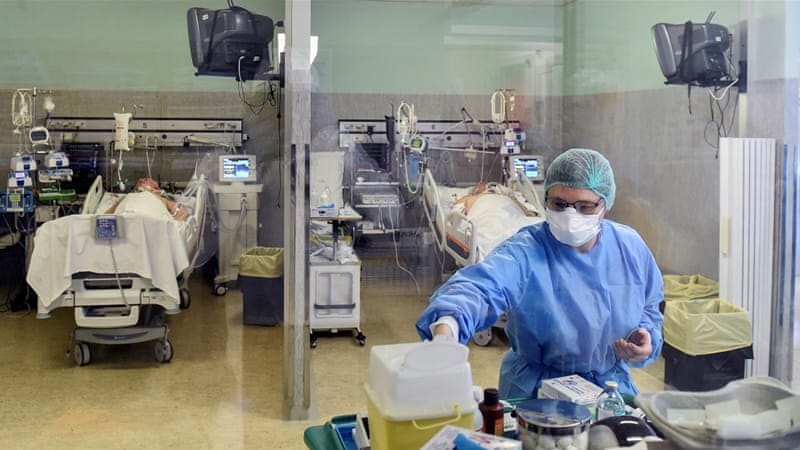 A medical worker treats patients suffering from COVID-19 in an intensive care unit at the Oglio Po hospital in Cremona, Italy on March 19, 2020 [File: Flavio Lo Scalzo/Reuters]