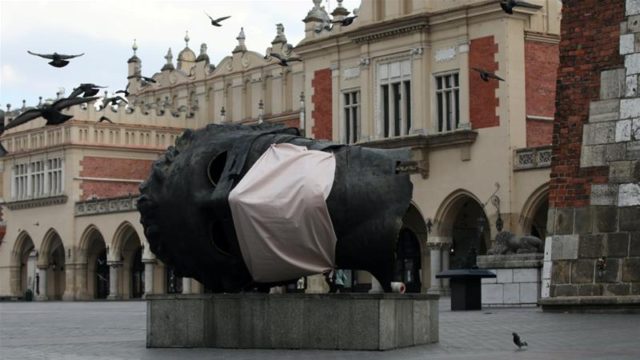 A sculpture Eros Bendato with a mock mask is seen on the main square during the coronavirus disease COVID 19 lockdown in Krakow Poland on March 23 2020