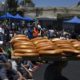 A youth walks by carrying loaves of bread as worshippers prepare to pray close to the Damascus Gate of the Old City in Jerusalem on July 25 2014