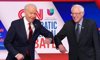 Joe Biden and Bernie Sanders do an elbow bump in place of a handshake before the start of the 11th Democratic candidates debate in Washington DC