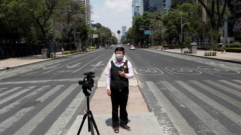 A journalist talks to the camera on Paseo de la Reforma avenue amid the lockdown in Mexico City on April 6 2020