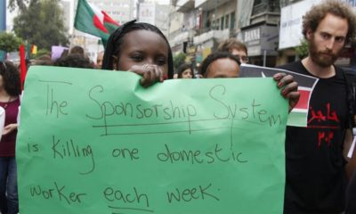 A migrant domestic worker holds up a placard during a parade in advance of May Day in Beirut on April 29 2012 1