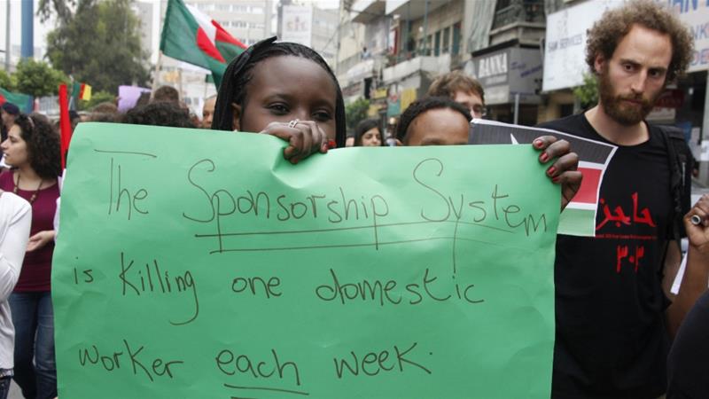A migrant domestic worker holds up a placard during a parade in advance of May Day in Beirut on April 29 2012