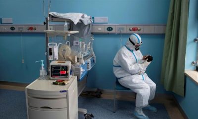 A nurse in a protective suit attends to a baby with COVID 19 at an isolation ward of Wuhan Childrens Hospital in Wuhan Hubei province China on March 16 2020