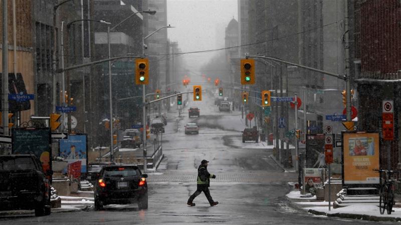 A pedestrian crosses a quiet downtown street as efforts continue to help slow the spread of coronavirus disease in Ottawa Canada on March 23 2020