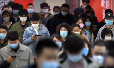 Commuters wear face masks to protect against the spread of new coronavirus as they walk through a subway station in Beijing on April 9 2020