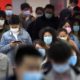 Commuters wear face masks to protect against the spread of new coronavirus as they walk through a subway station in Beijing on April 9 2020