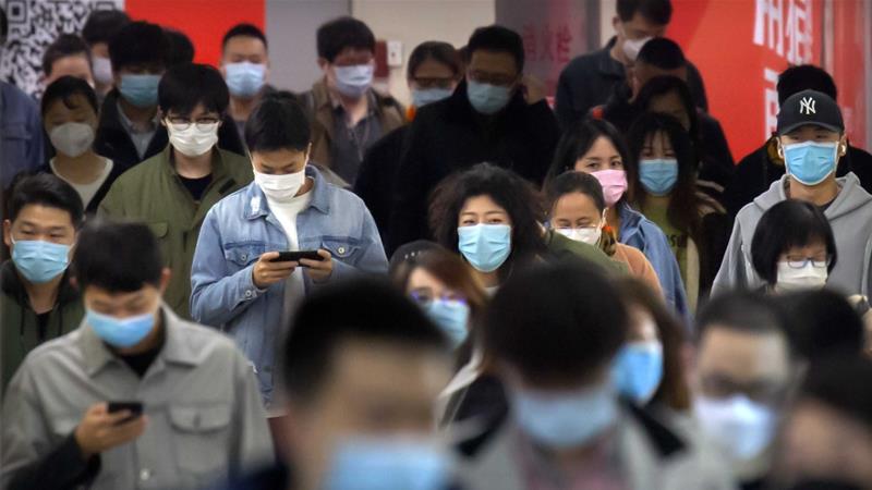 Commuters wear face masks to protect against the spread of new coronavirus as they walk through a subway station in Beijing on April 9 2020