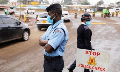 Kenyan police officers check vehicles at a roadblock to control traffic coming into Nairobi during a partial lockdown on April 7 2020