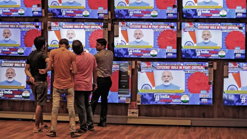 People watch Indian Prime Minister Narendra Modi address the nation amid concerns about the spread of coronavirus inside a showroom in Ahmedabad India on March 19 2020