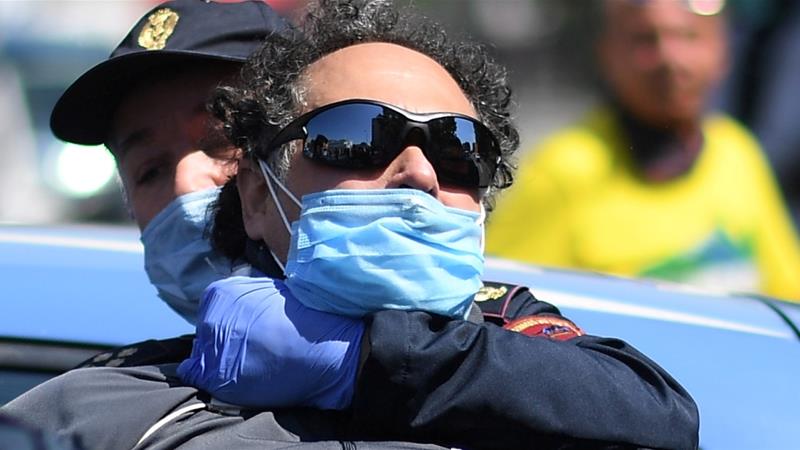 Police detain a man who was putting red banners on memorial plaques dedicated to Italian partisans on Liberation Day amid the lockdown in Milan Italy on April 25 2020